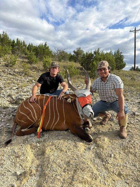 Two crew members with a bongo on a rocky slope