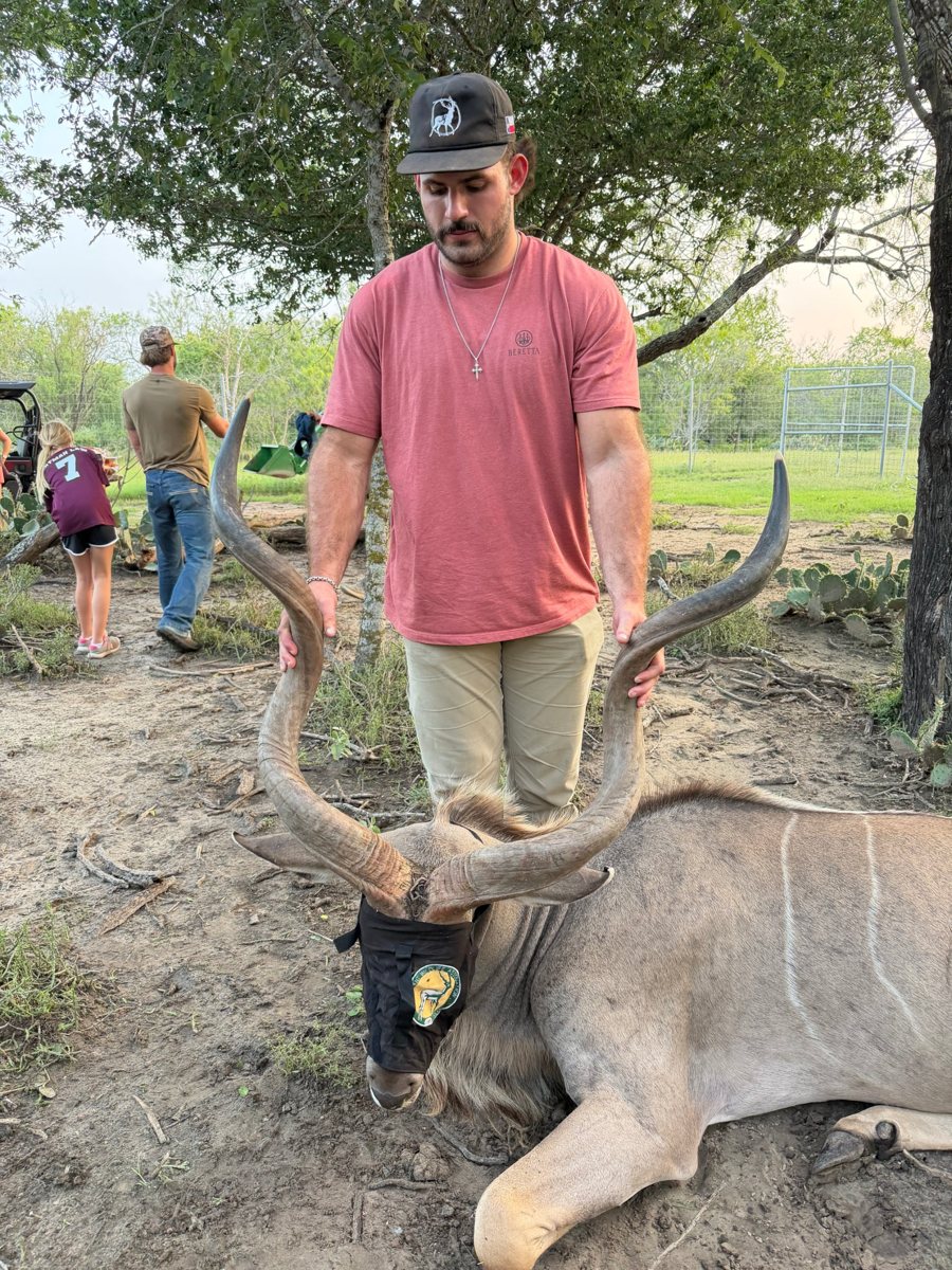 One of the brothers holding the horns of a greater kudu bull